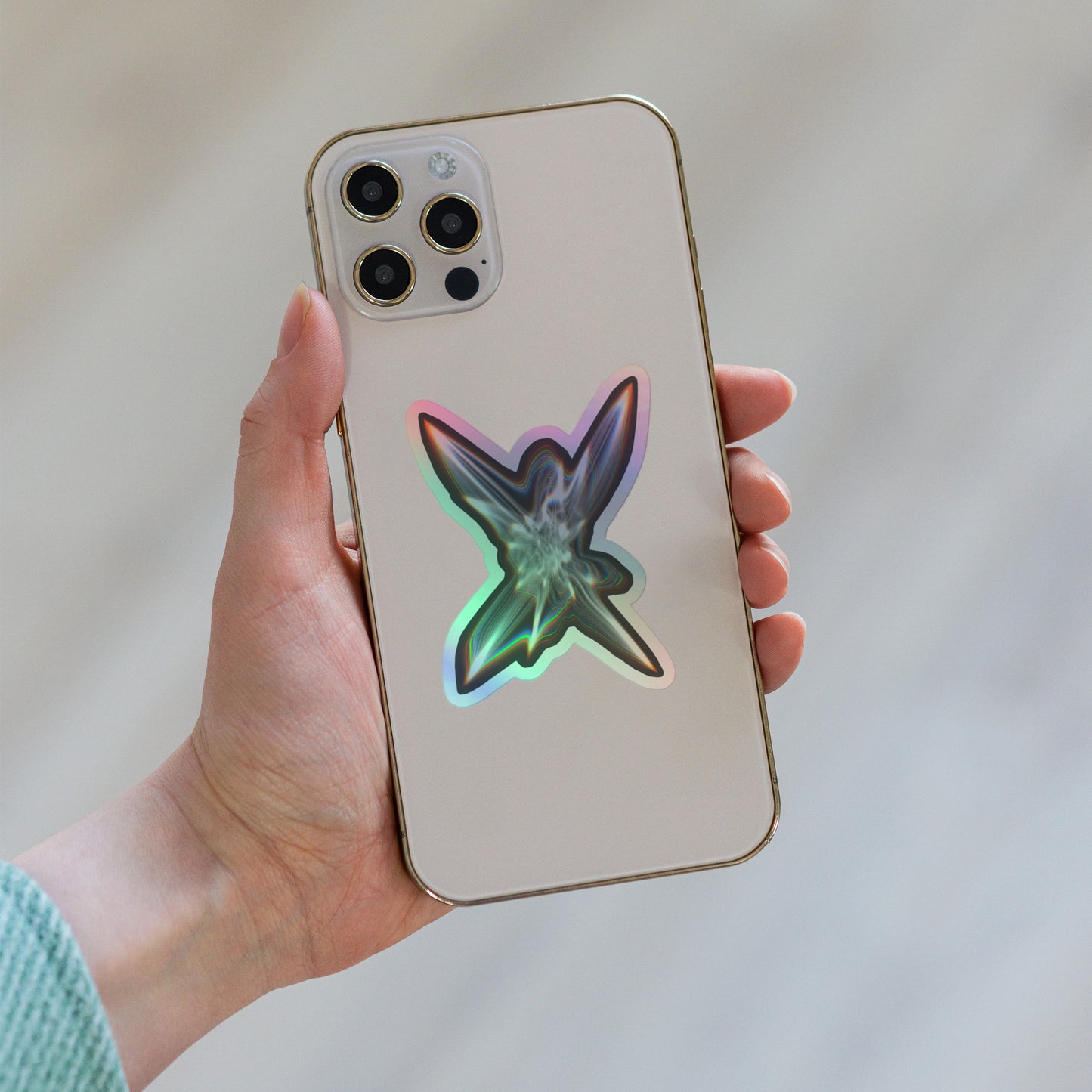 The Light Within Holographic sticker on a phone that someone is holding in their hand.